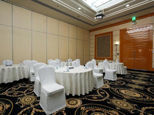 a conference room with white tables and white chairs at Sheraton Dammam Hotel & Convention Centre in Dammam
