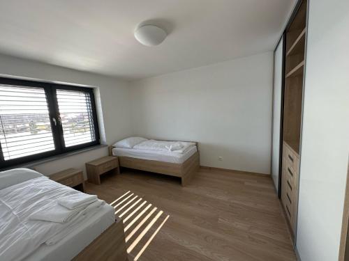a bedroom with two beds and a window at Lake House 513 in Šajdíkove Humence