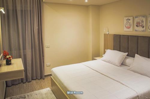 a bedroom with a large white bed and a window at شقة فندقية الشيخ زايد - Zayed Suites F in Sheikh Zayed
