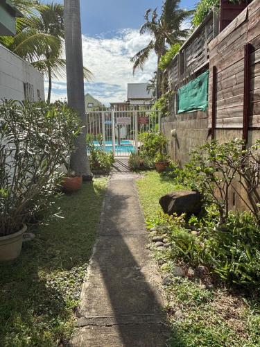 a pathway leading to a pool in a yard at Villa Pétrel in Saint-Paul