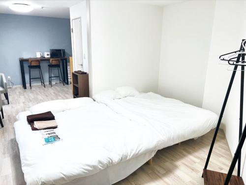 a bedroom with a white bed and a desk at Villa Hayabusa in Osaka
