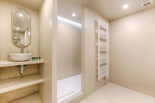 une salle de bain avec un lavabo et un miroir dans l'établissement Residence - Roquette - Marais, à Paris