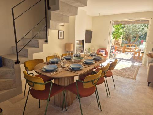 une salle à manger avec une table et des chaises en bois dans l'établissement LA MAISON DU PETIT PORT 8mn de St Tropez Entièrement rénovée en 2025, à Cogolin