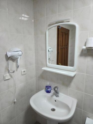 a white bathroom with a sink and a mirror at Hotel Aşıkoğlu in Bogazkale