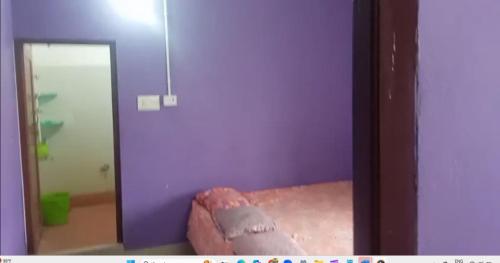 a mirror in a room with a purple wall at Sri Chaitanya Saraswat Math in Krishnanagar