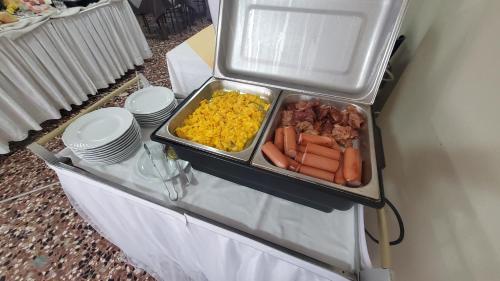 a buffet with a tray of food on a table at Alevon Hotel in Rimini