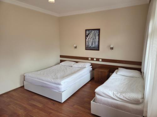 two beds in a room with white sheets at Hotel Aşıkoğlu in Bogazkale