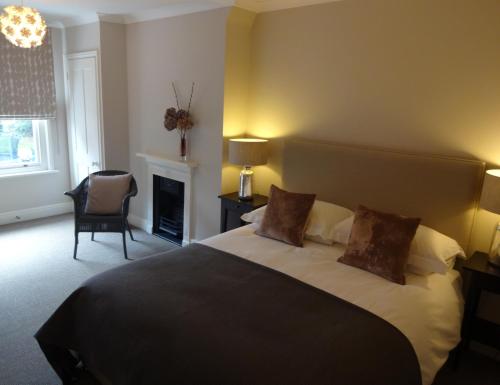 Un dormitorio con una cama grande y una chimenea. en Ogilvy House, en Cromer