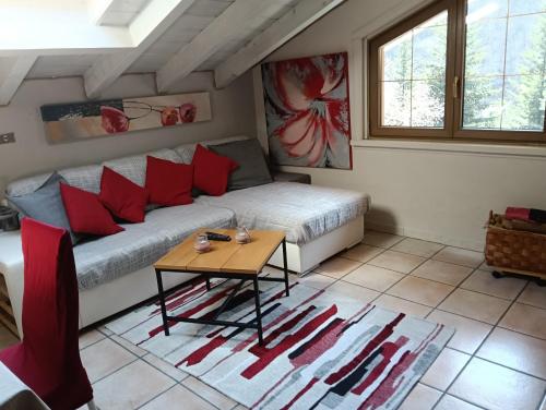 a bedroom with a bed with red pillows and a table at CASA ELISA in Cavaglio San Donnino