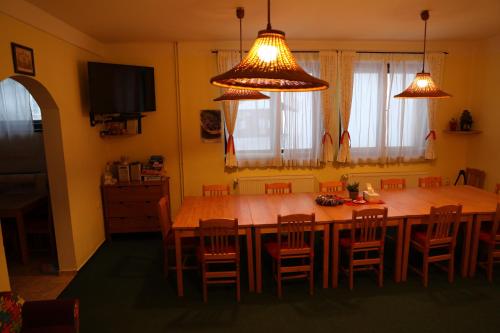a kitchen with a large wooden table and chairs at U Fary in Jestrabi V Krkonosich