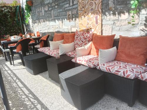 a wicker couch with pillows sitting on a patio at CASA ELISA in Cavaglio San Donnino