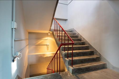 a staircase with a red railing in a building at 眷村1954 Guest House in Taipei