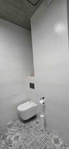 a white bathroom with a toilet in a room at Apartament Centrum 19 in Nowy Sącz