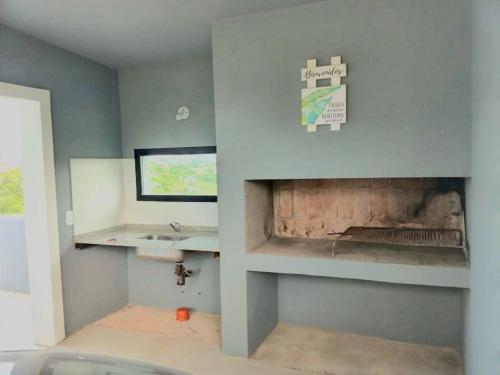 a bathroom with a fireplace and a sink at Nuestras raíces 1 in Villa Carlos Paz
