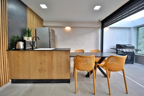 a kitchen with a table with chairs and a refrigerator at פנטהאוז 125 - פנטהאוז, דירת אירוח וגג מהמם לאירועים עם בריכה וגקוזי in Nahariyya