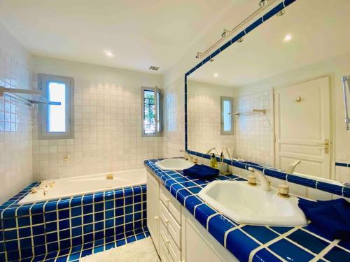 une salle de bain avec deux lavabos et un grand miroir dans l'établissement Beautiful 5 bedroom villa with direct sea view, à Antibes