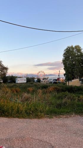 a field with a ferris wheel in the distance at Nafpaktio home in Nafpaktos