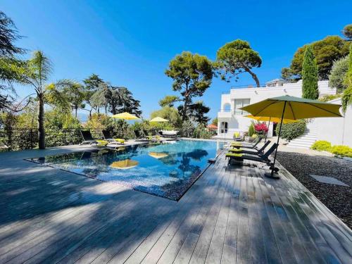 une piscine avec des chaises et un parasol dans l'établissement Beautiful 5 bedroom villa with direct sea view, à Antibes