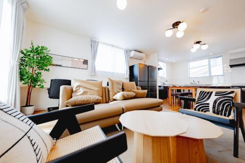 a living room with a couch and a table at Furano Ezo Murasaki A in Furano