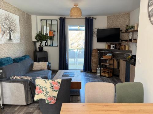 un salon avec un canapé et une table dans l'établissement Chez Gwen et Marie, à Bogny Sur Meuse