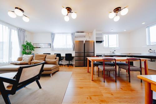 a living room with a couch and a table at Furano Ezo Murasaki A in Furano