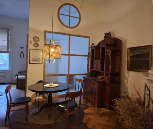 a living room with a table and chairs and a window at ANNO 1800 in Bistriţa