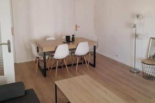 une salle à manger avec une table et des chaises blanches dans l'établissement Bel appartement Perpignan 15 min de la mer, à Perpignan