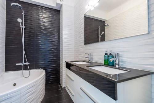 une salle de bain avec un lavabo, une baignoire et une douche dans l'établissement Modern Sea View Apartment on Promenade des Anglais, à Nice