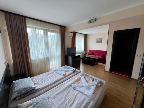 a bedroom with a bed and a living room at Хотел Валентино 2 in Dobrinishte