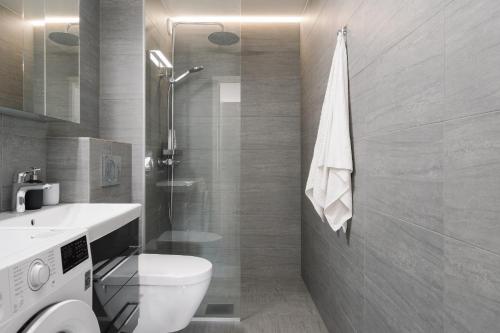 a bathroom with a toilet and a sink and a shower at 1BR City Apartment with Balcony Next to the Sea in Helsinki