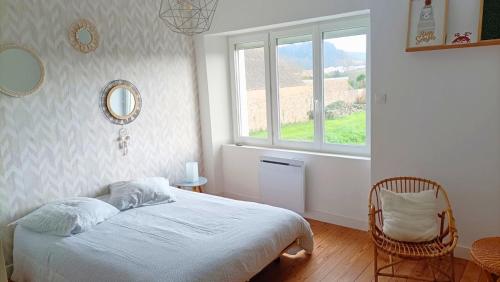 une chambre avec un lit, une fenêtre et une chaise dans l'établissement Maison familiale proche de la mer, à Surtainville
