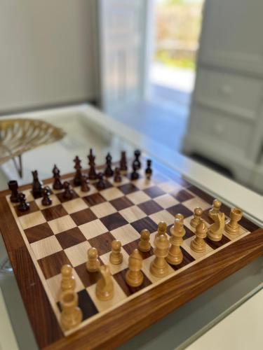 a wooden chess board with chess pieces on it at Chrisi Holiday Home - 500 sqm Private Gardens & Nature View - 300m by the sea in Almyrida