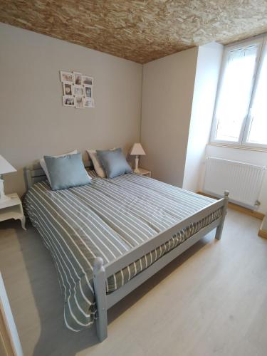 a bedroom with a large bed with blue pillows at Le Logis de Jade in Saint-Léon