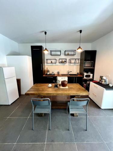 une cuisine avec une grande table en bois et deux chaises dans l'établissement Havre de paix proche de Nice, à Falicon