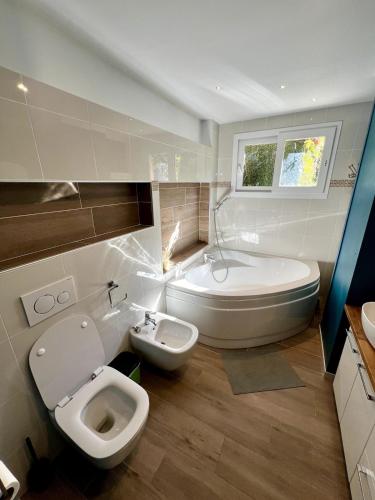 une salle de bain avec toilettes, baignoire et lavabo dans l'établissement Havre de paix proche de Nice, à Falicon