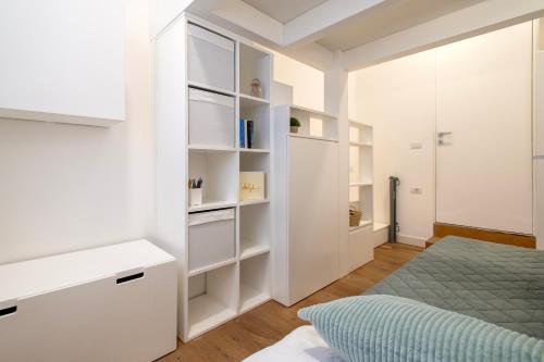 a white bedroom with a bed and a closet at CASA ANTO - Charming apartment 50 meters from the beach in Alghero