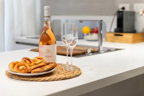 a bottle of wine and a plate of pretzels and a glass at CASA ANTO - Charming apartment 50 meters from the beach in Alghero