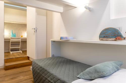 a bedroom with a bed and a desk in a room at CASA ANTO - Charming apartment 50 meters from the beach in Alghero