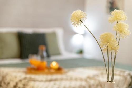 two flowers in a vase on a table at CASA ANTO - Charming apartment 50 meters from the beach in Alghero
