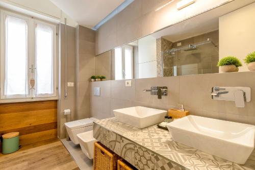 a bathroom with two sinks and a mirror at CASA ANTO - Charming apartment 50 meters from the beach in Alghero