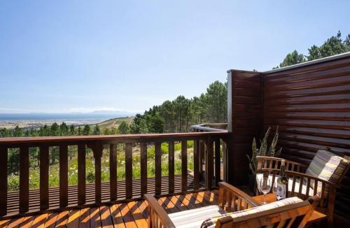 a wooden deck with two chairs and a table on it at Guided Tour of Belhar South Africa in Belhar