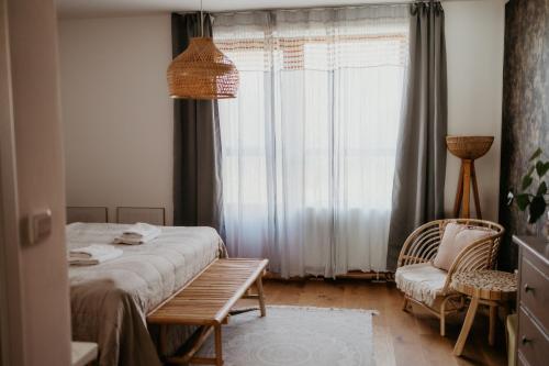 a bedroom with a bed and a chair and a window at Simply rooms in Slavkov u Brna
