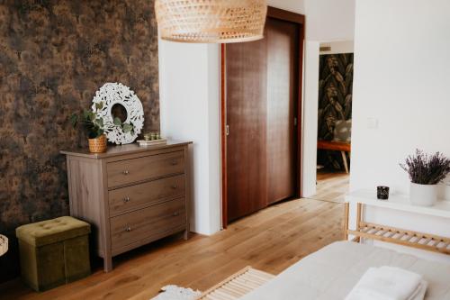 a bedroom with a bed and a dresser at Simply rooms in Slavkov u Brna
