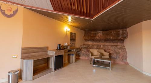 a room with a stone wall with a table and chairs at Mars Land Luxury Camp in Wadi Rum