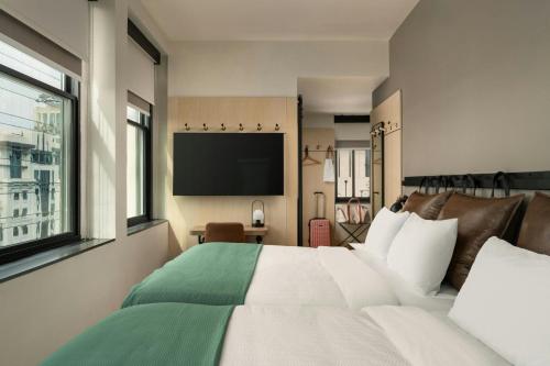 a bedroom with a bed and a flat screen tv at Moxy Columbia Downtown in Columbia