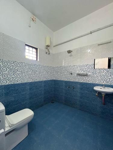 a bathroom with a toilet and a sink at Tropical Villa in Varkala