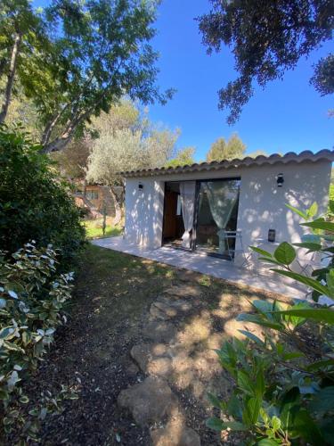 - un bâtiment blanc avec une fenêtre dans une cour dans l'établissement Chambre à louer, à Laouque