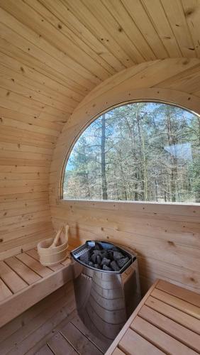 a wooden sauna with a large window in it at Mazurska bania u Pana Szeptuna - drewniany dom na skraju lasu in Lidzbark