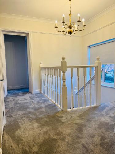 a staircase in a home with a chandelier at Modern 4BR House with Parking, 8 Mins to Gatwick Airport in Crawley