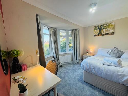 a bedroom with a bed and a desk and a window at Modern 4BR House with Parking, 8 Mins to Gatwick Airport in Crawley